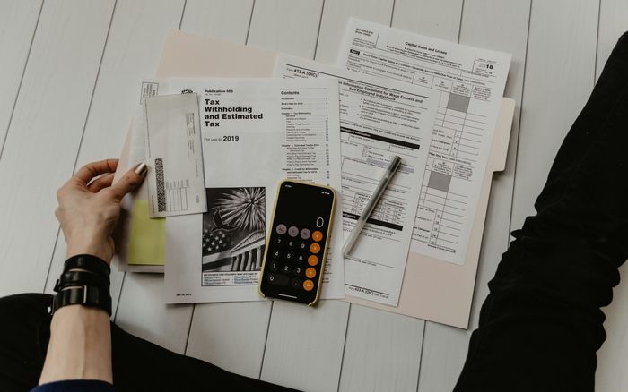 Paperwork, a pen and a calculator on a desk