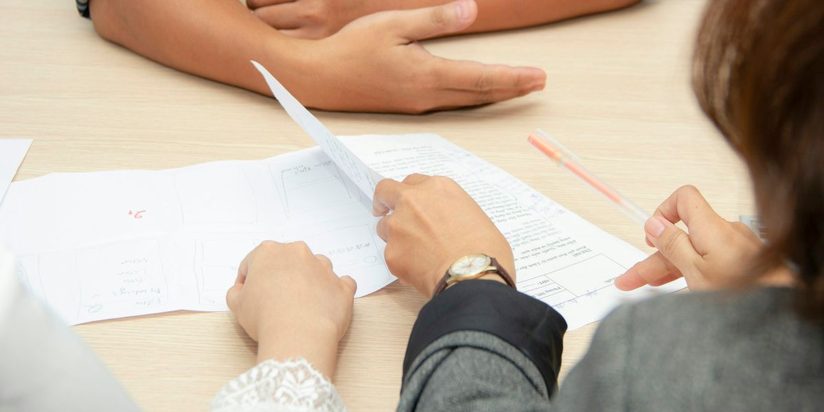 Two people reviewing loan documents at a meeting table