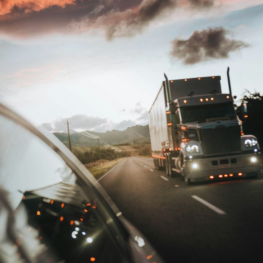 A truck driving along a New Zealand highway in evening light
